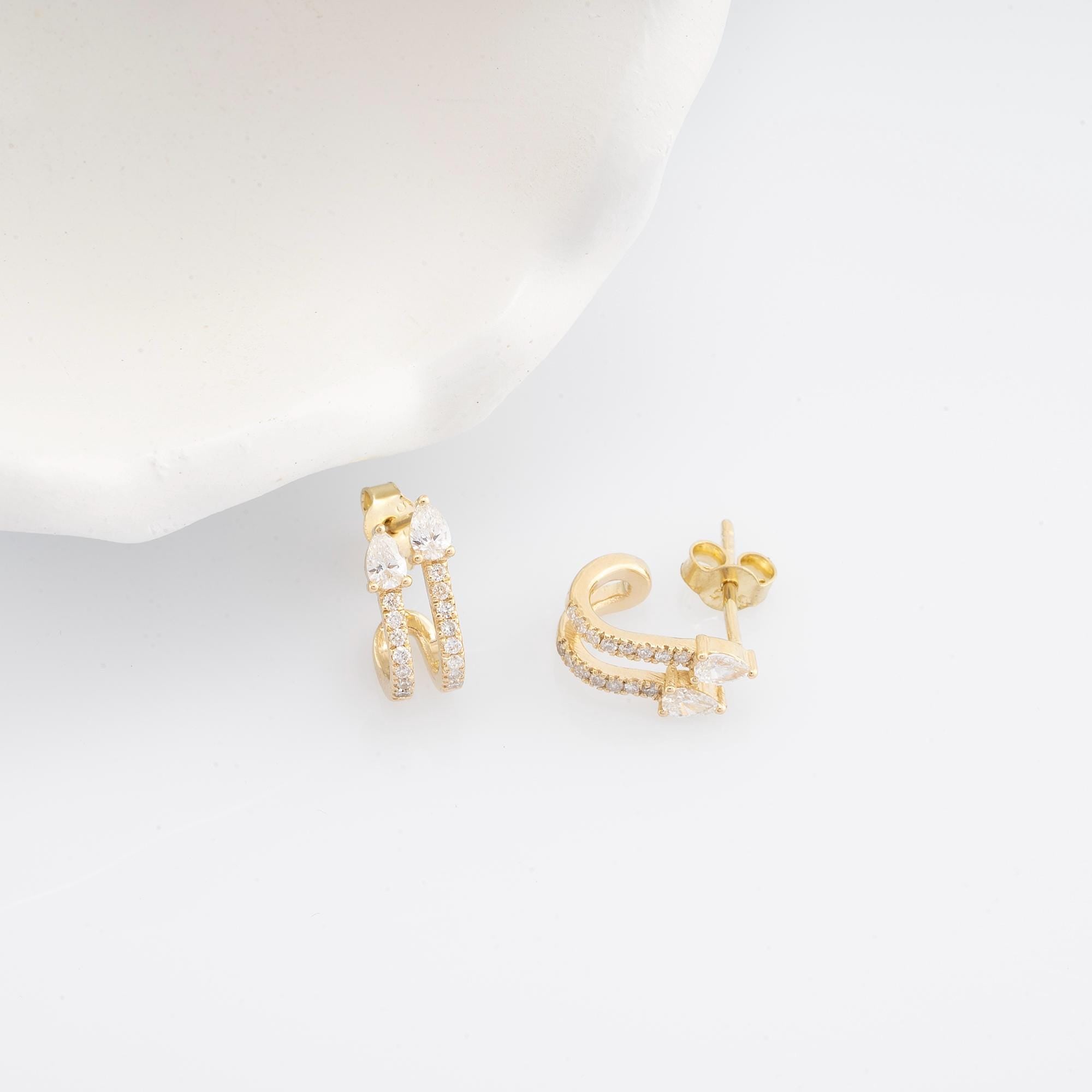 14K gold diamond double huggie earrings with round and pear-cut diamonds. Perfect for everyday luxury or special occasions, adding a brilliant sparkle to any outfit.